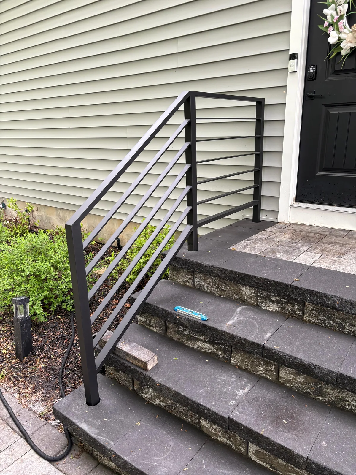 Black metal railing, stone steps